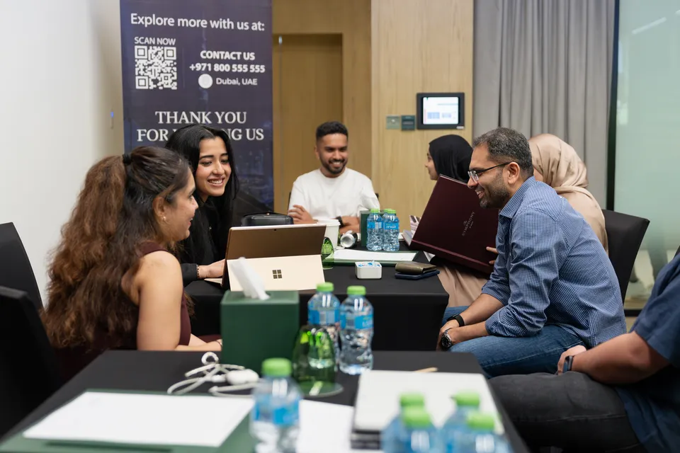 Visitors talk with advisers at a consultation table, under the expo's thank-you and contact banner