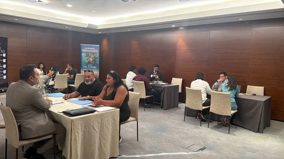 The expo floor, with several consultation tables spread across a wood-panelled room near a DAMAC Islands 2 banner