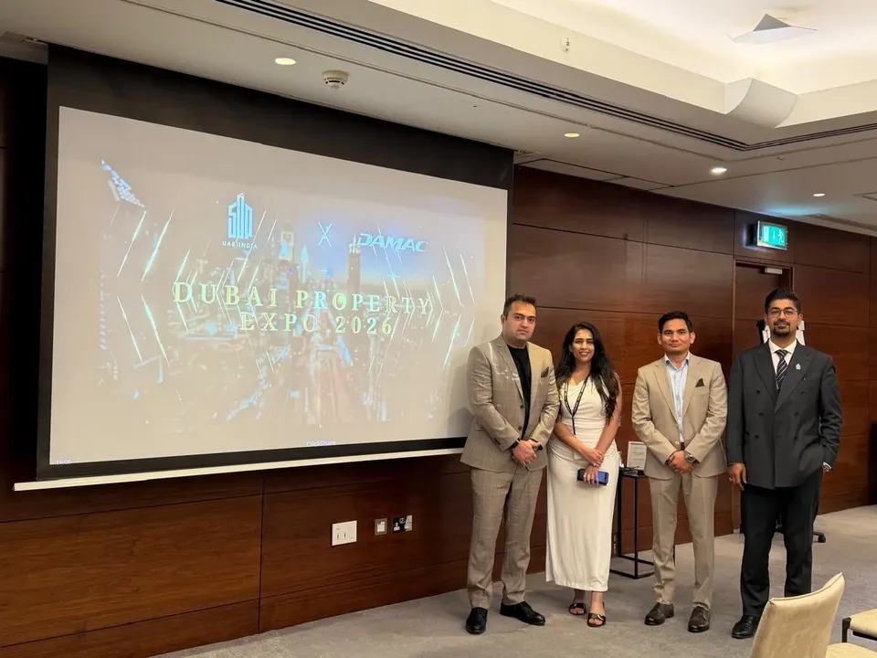 Four people pose in front of a screen showing the Dubai Property Expo 2026 title slide, with a DAMAC logo above it